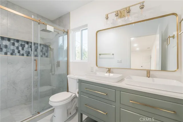 a bathroom with a sink a toilet and shower