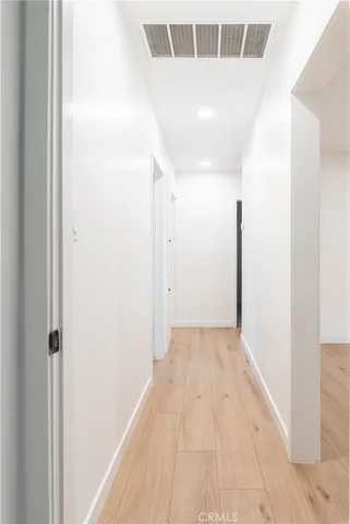 a view of a hallway with wooden floor