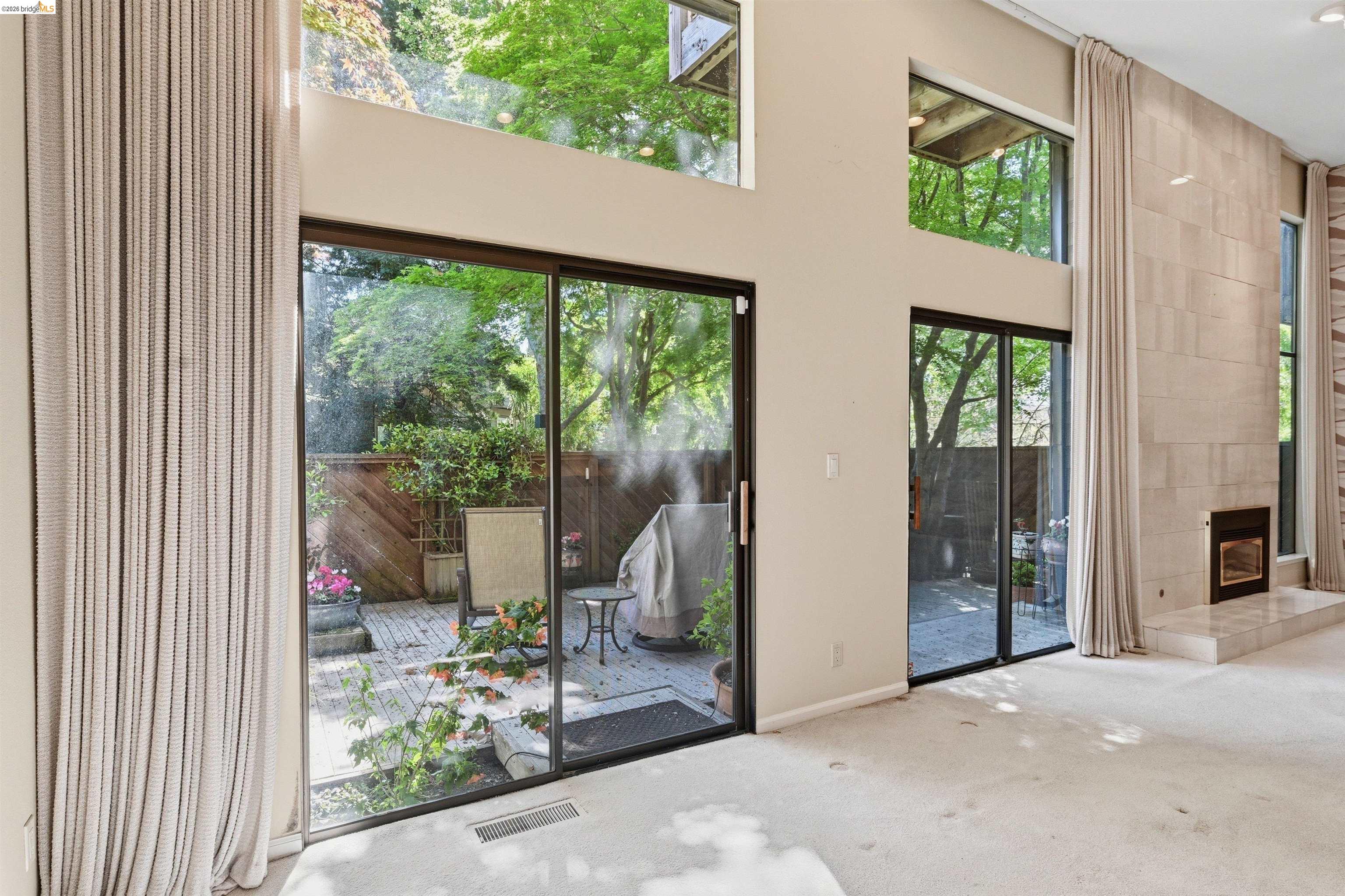 1925 Piper Ridge Court Walnut Creek, CA 94597 - Photo 4 of 27 Doorway to outside featuring carpet floors, a high ceiling, and a tiled fireplace