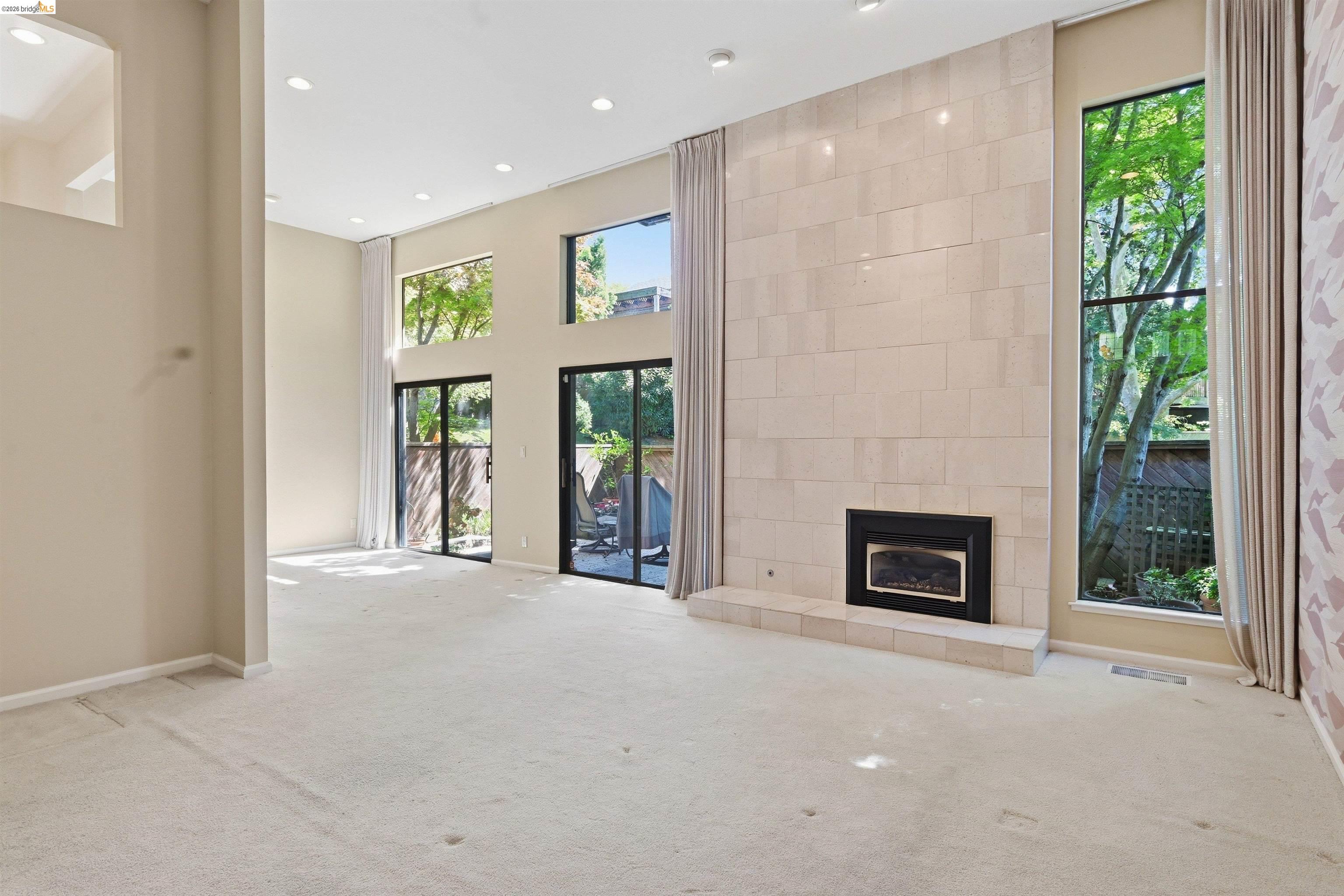 1925 Piper Ridge Court Walnut Creek, CA 94597 - Photo 6 of 27 Unfurnished living room with a high ceiling, light carpet, a tiled fireplace, and recessed lighting