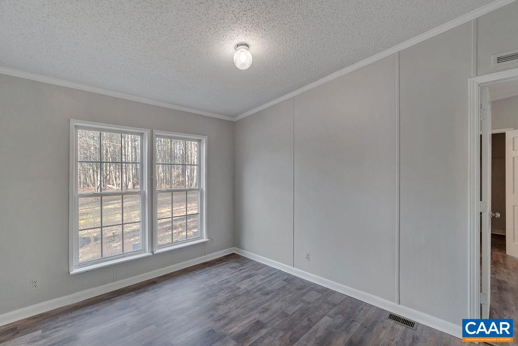 867 Scotts Bottom Road Dillwyn, VA 23936 - Photo 16 of 29 an empty room with wooden floor cabinet and windows