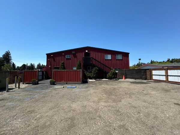 a view of a house with a yard and wooden fence