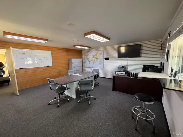 a view of a workspace with furniture and a window