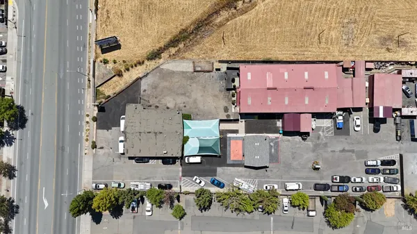 an aerial view of residential houses with outdoor space and parking