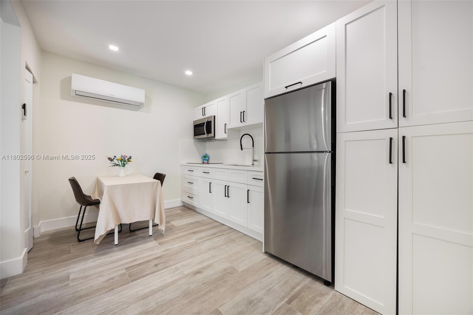 2478 Inagua Avenue Coconut Grove, FL 33133 - Photo 14 of 40 a kitchen with stainless steel appliances a refrigerator sink dining table and chairs