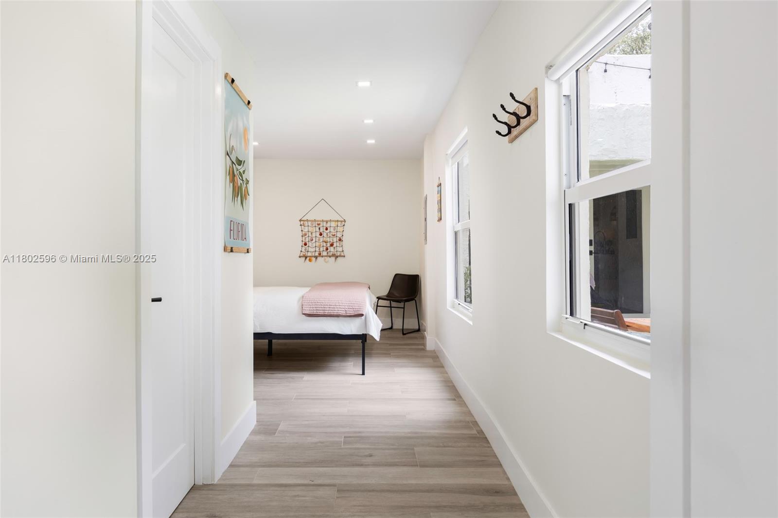 2478 Inagua Avenue Coconut Grove, FL 33133 - Photo 16 of 40 a view of a hallway with wooden floor and a bathroom