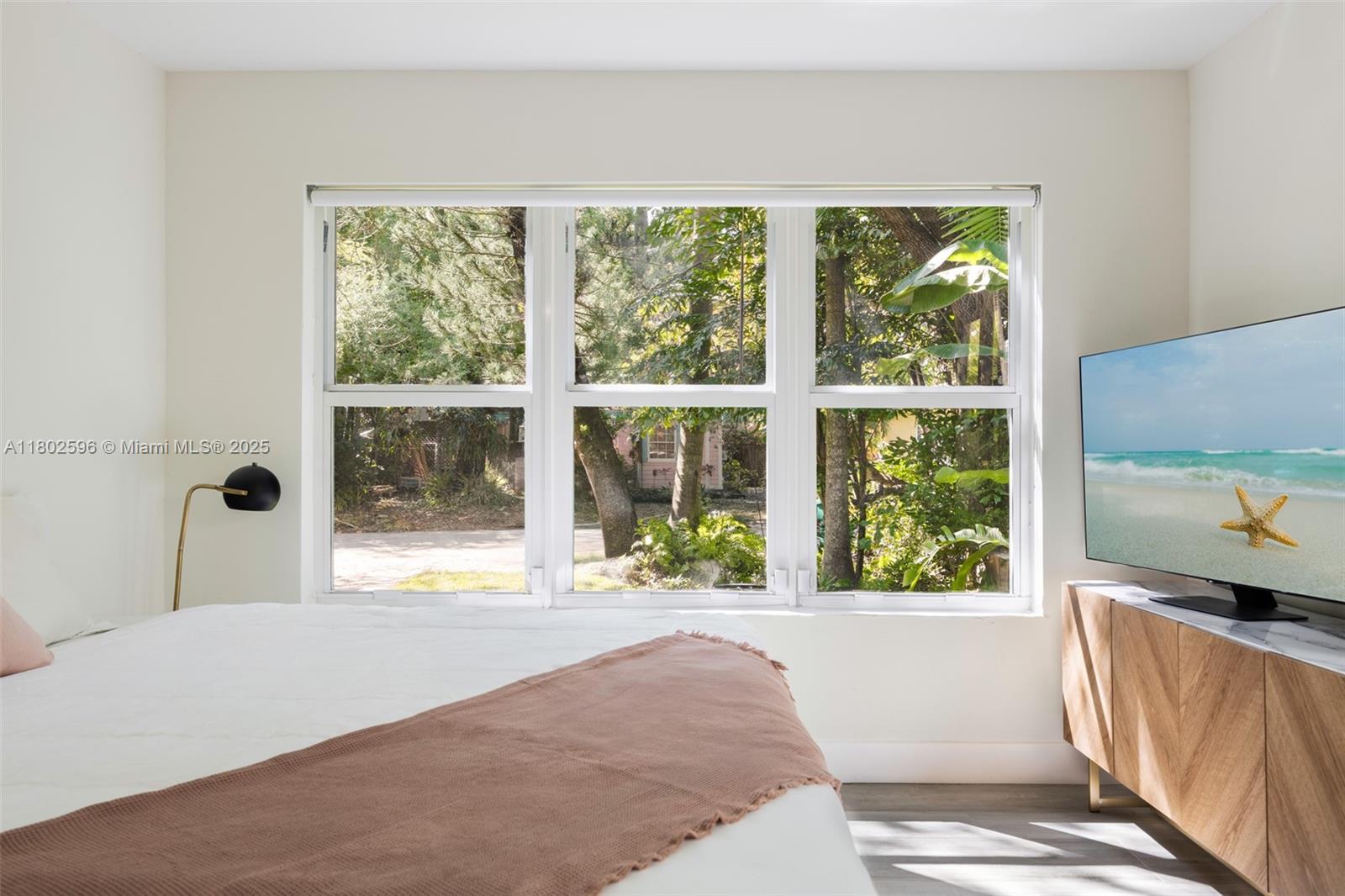 2478 Inagua Avenue Coconut Grove, FL 33133 - Photo 23 of 40 a living room with a large window and a bed