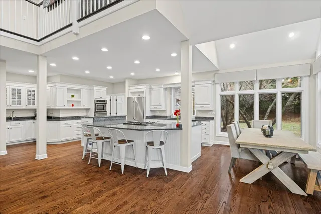 a kitchen with stainless steel appliances granite countertop a living room dining room and wooden floor