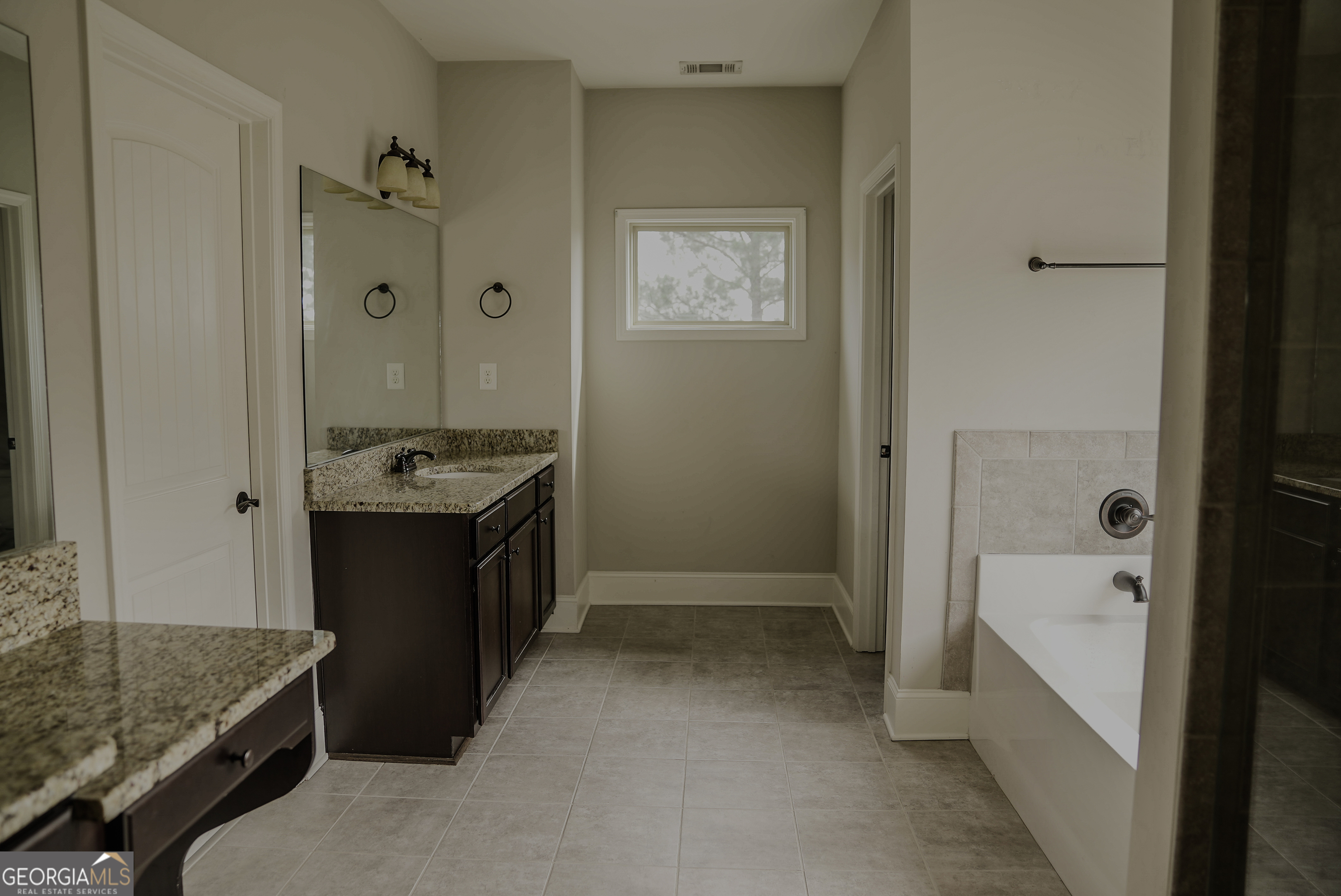 505 Mirror Lake Parkway Villa Rica, GA 30180 - Photo 12 of 28 a bathroom with a sink a mirror and a bathtub