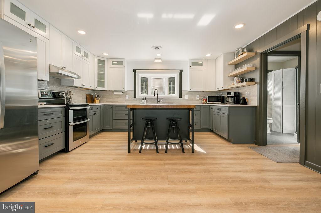 1321 Marsh Hill Road McHenry, MD 21541 - Photo 3 of 42 a kitchen with stainless steel appliances kitchen island granite countertop a table chairs sink refrigerator and cabinets
