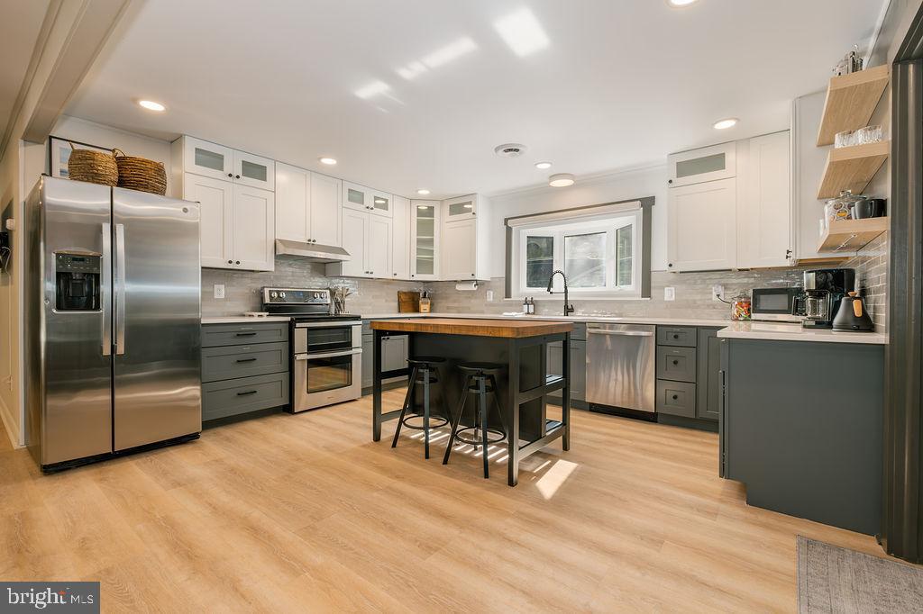 1321 Marsh Hill Road McHenry, MD 21541 - Photo 4 of 42 a kitchen with stainless steel appliances a sink a stove a refrigerator cabinets and a dining table