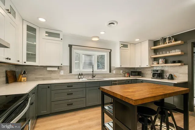 a kitchen with a sink a stove and cabinets