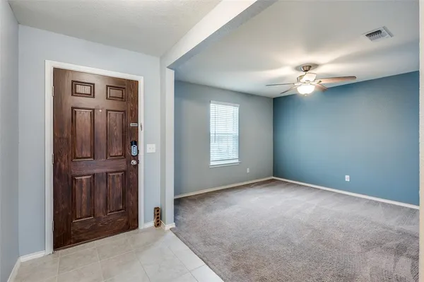 an empty room with closet and a ceiling fan