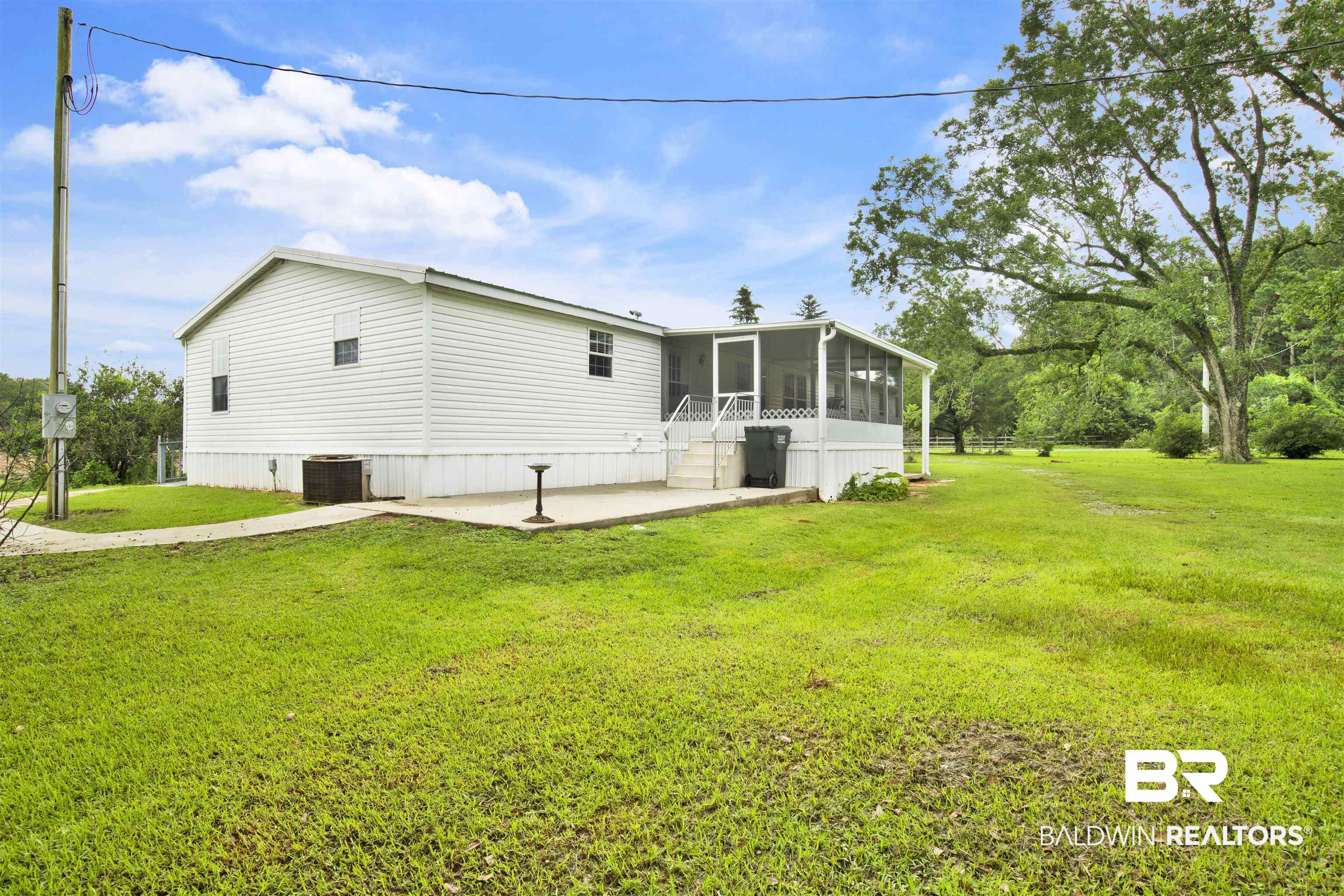 25700 County Road 71 Robertsdale, AL 36567 - Photo 29 of 40 Rear view of house featuring a sunroom, a patio, and a yard