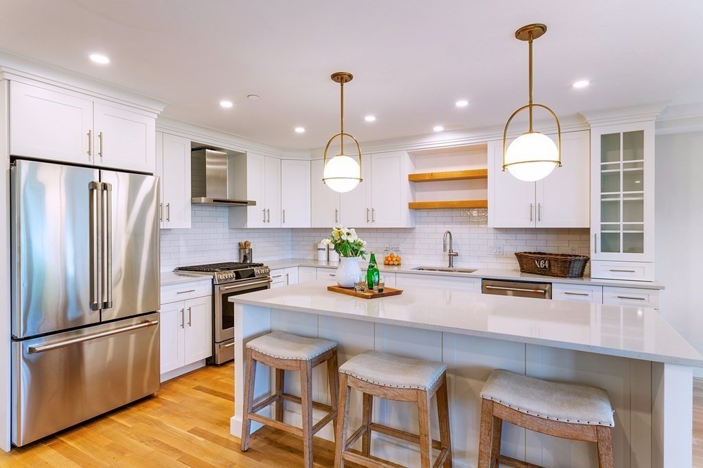 163 Atlantic Road, Unit 6 Gloucester, MA 01930 - Photo 6 of 22 a kitchen with granite countertop stainless steel appliances a table chairs stove refrigerator and microwave