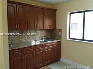 a kitchen with granite countertop wooden cabinets a sink and dishwasher