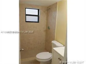 a white toilet sitting next to a shower