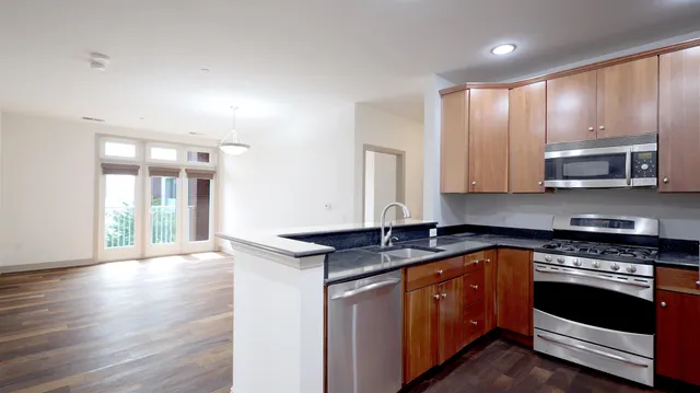 a kitchen with stainless steel appliances granite countertop a stove a sink and a microwave
