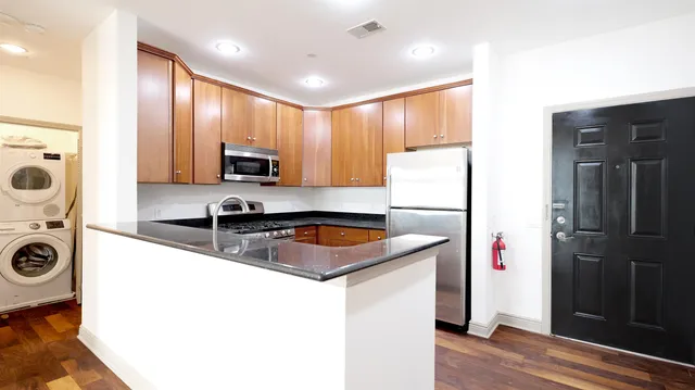 a kitchen that has a sink a refrigerator and cabinets