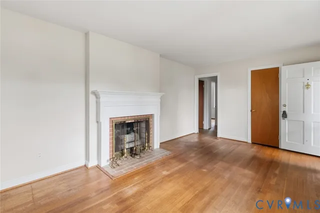 a view of a livingroom with wooden floor and a fireplace