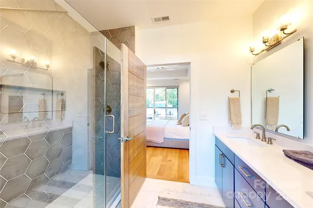 a en suite bathroom with a granite countertop sink mirror and shower