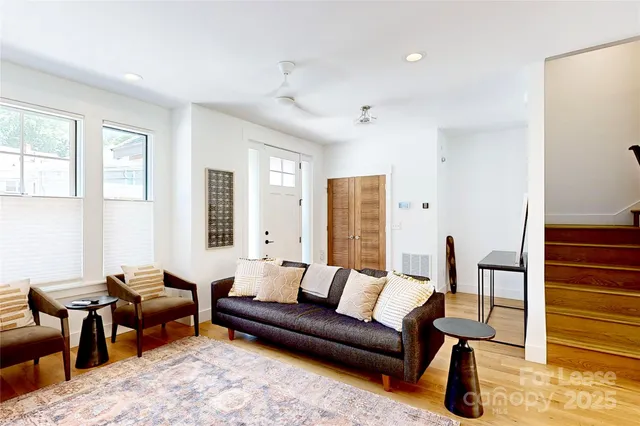 a living room with furniture wooden floor and a window