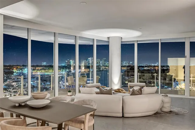 a living room with furniture a large window and kitchen view