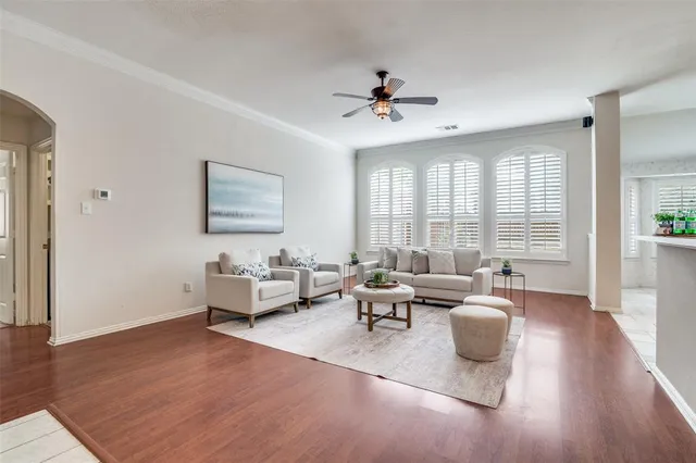 a living room with furniture floor to ceiling window and wooden floor