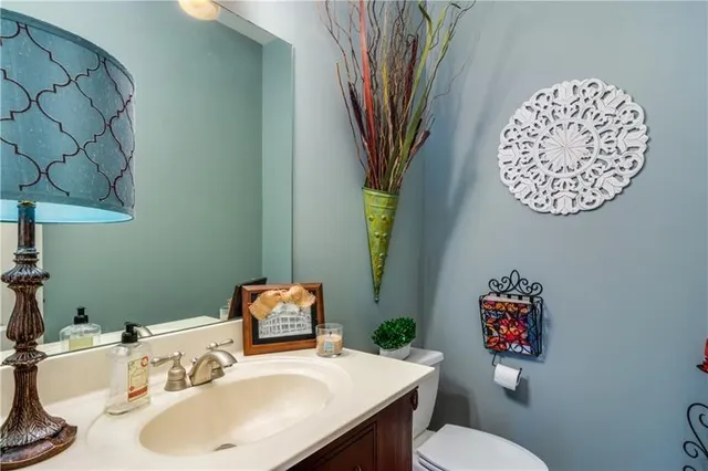a bathroom with a sink mirror vanity and toilet