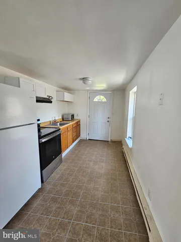 a view of a kitchen with a sink and an empty room