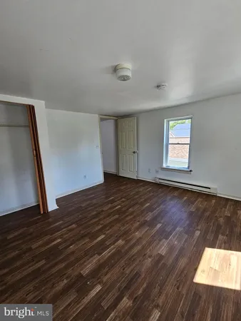 a view of a livingroom with wooden floor and window