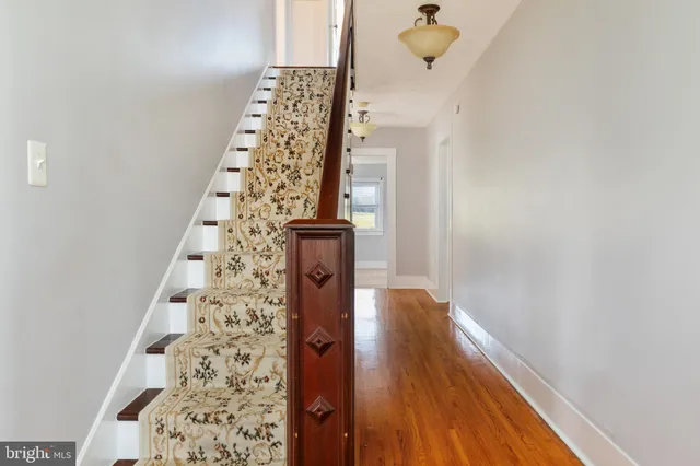 a view of a hallway with wooden floor and entryway