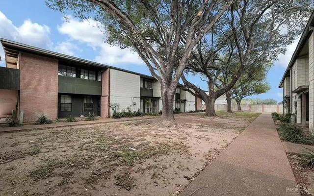 a front view of a house with a tree