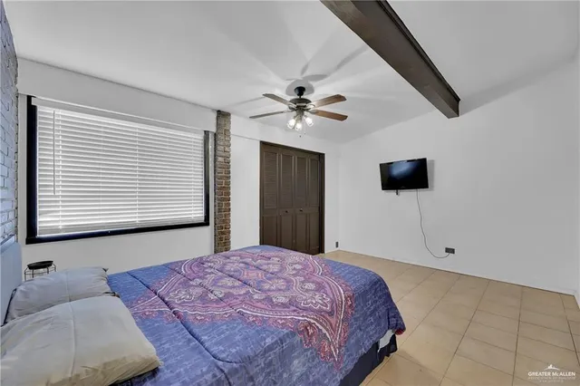 a bedroom with a large bed and a flat tv screen