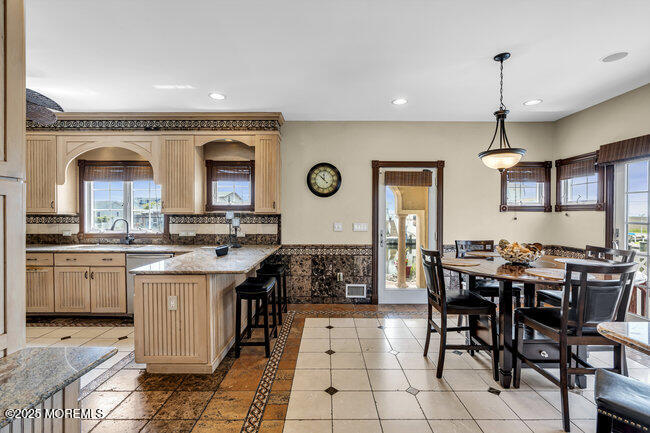 835 Anchor Drive Forked River, NJ 08731 - Photo 97 of 146 a kitchen with stainless steel appliances granite countertop a stove top oven a sink a dining table and chairs with wooden floor