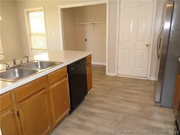 a kitchen with granite countertop a sink and a refrigerator
