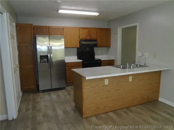 a view of kitchen with stainless steel appliances wooden cabinet refrigerator and microwave