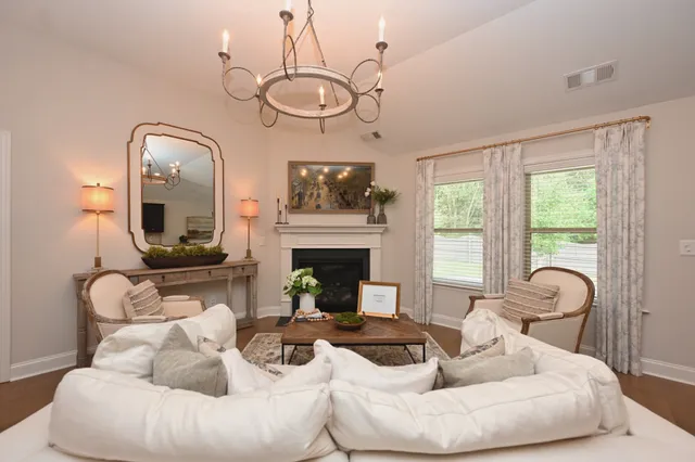 a living room with furniture a fireplace and a large mirror