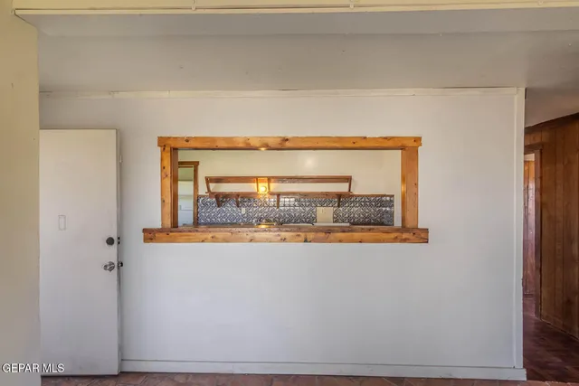 a view of an empty room with a fireplace and a window
