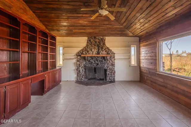 a view of an empty room with furniture and window