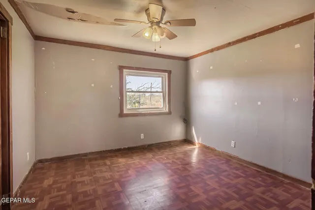 a view of an empty room with a chandelier fan