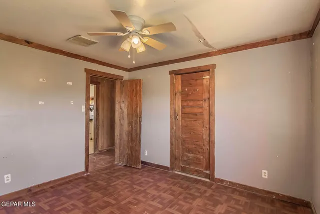 an empty room with a window and a fan