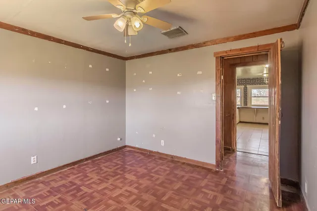 an empty room with closet and a chandelier fan