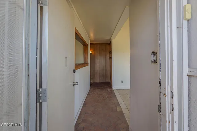 a view of a hallway with wooden shelves