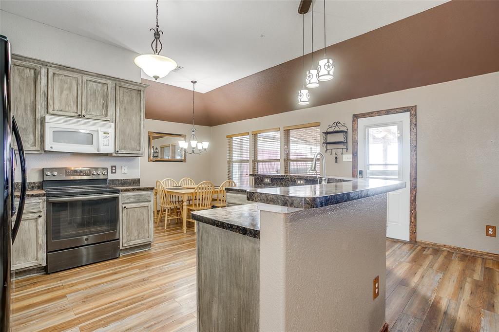 10905 Soft Shell Drive Venus, TX 76084 - Photo 13 of 21 a kitchen with stainless steel appliances granite countertop a stove cabinets and wooden floor