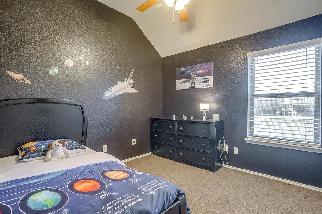 10905 Soft Shell Drive Venus, TX 76084 - Photo 19 of 21 a bedroom with a bed and a chandelier