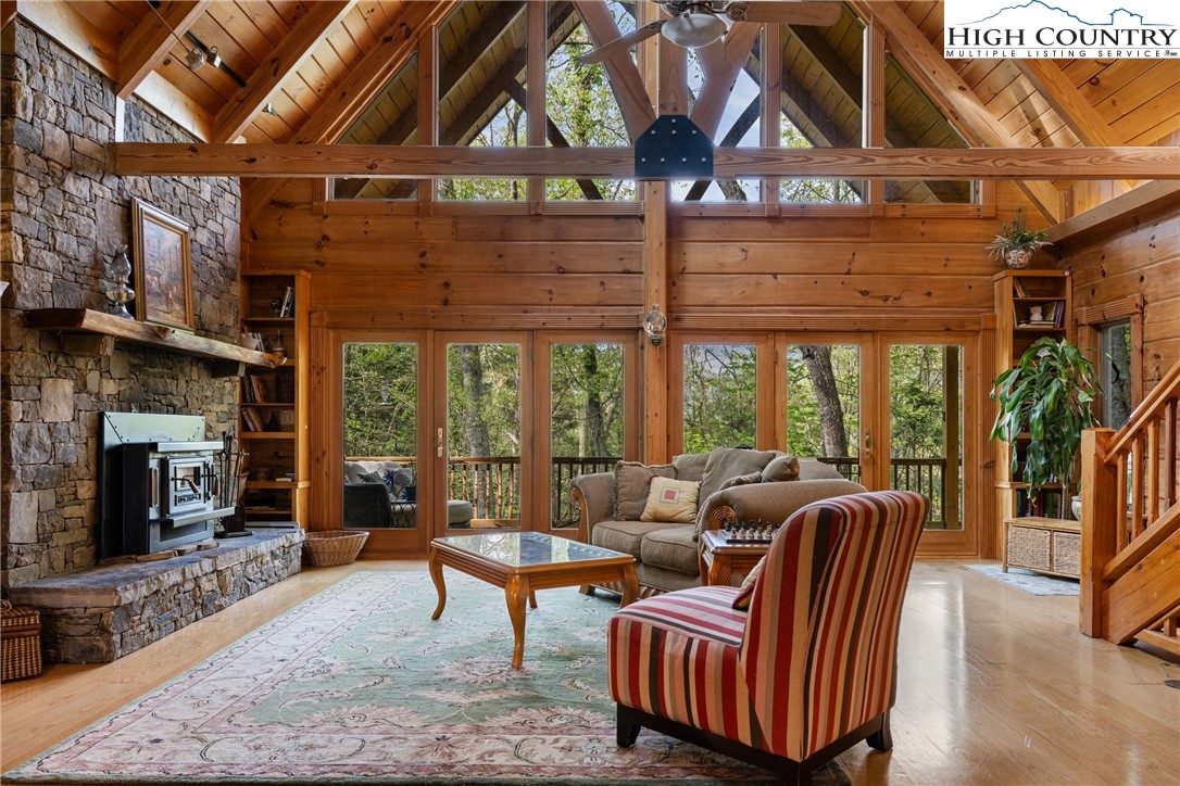 286 B Howell Road Lansing, NC 28643 - Photo 7 of 47 a living room with furniture a fireplace and a ceiling fan