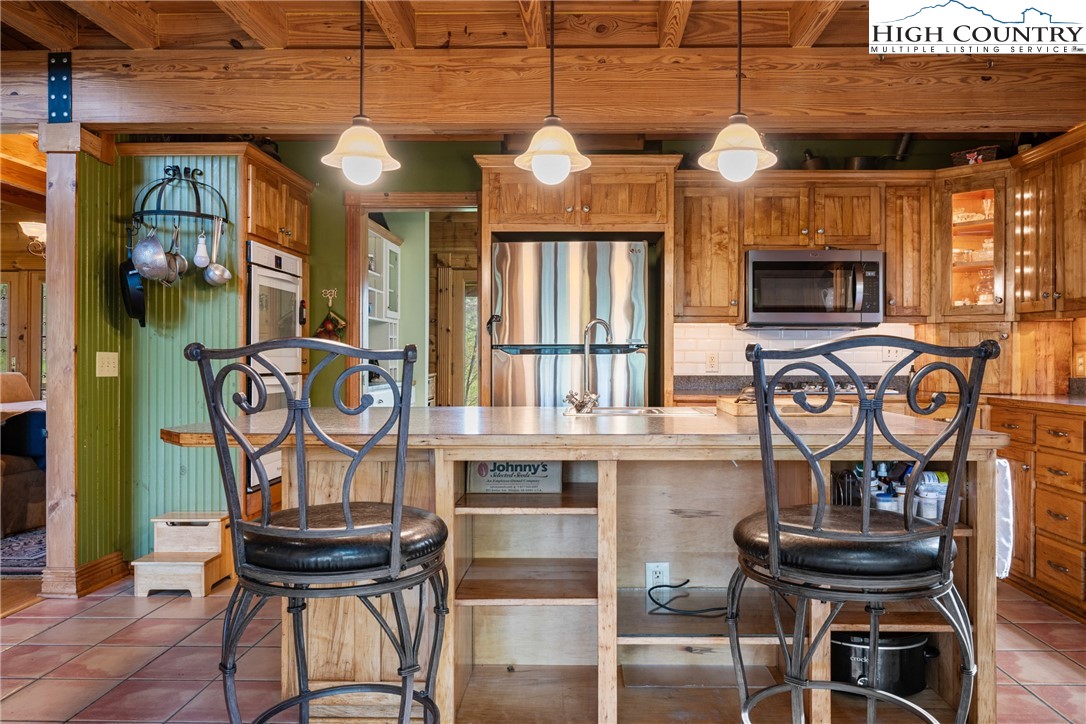286 B Howell Road Lansing, NC 28643 - Photo 8 of 47 a view of a kitchen with stainless steel appliances granite countertop a stove and cabinets