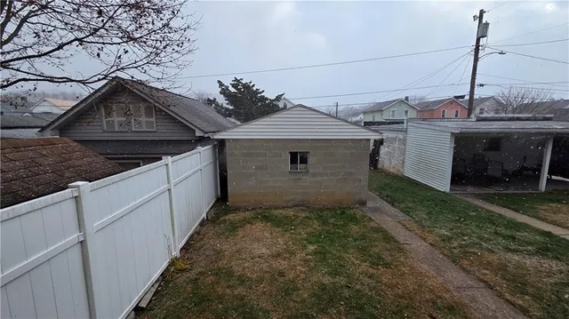 a backyard of a house with dishwasher and wooden fence