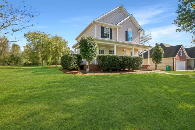 a front view of a house with a yard and trees